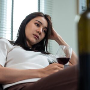 Asian Woman on the sofa drinking wine