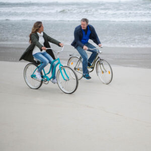Couple riding bikes on the beach 1000