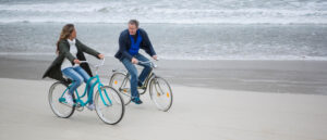 Couple riding bikes on the beach 2560