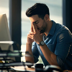 Man at desk in front of computer stressed about life 1000