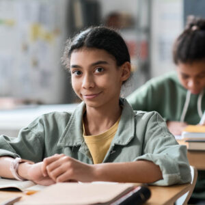 Middle School Girl sitting at desk in School room 1000