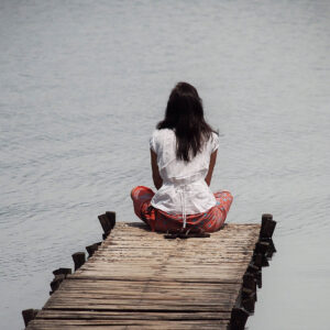 Woman sitting at the end of a dock thinking about what to do next