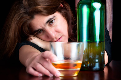 Woman looking at alcohol on the table trying to take control - maybe it is time to contact a counselor at Wyndhurst Counseling Center Lynchburg Va