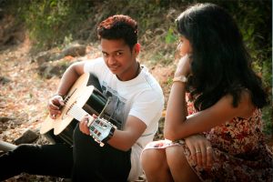 Young couple in love playing guitar 600